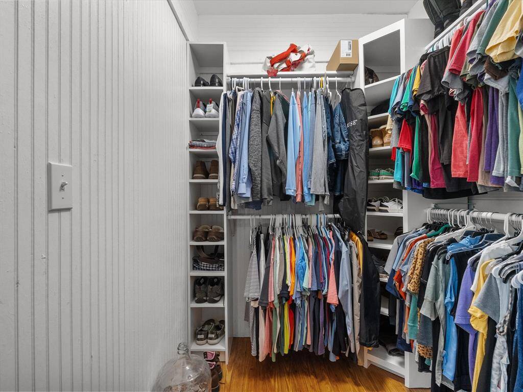 This photo showcases a spacious walk-in closet with ample shelving and hanging space, featuring neatly organized clothes and shoes, perfect for efficient storage in a home.