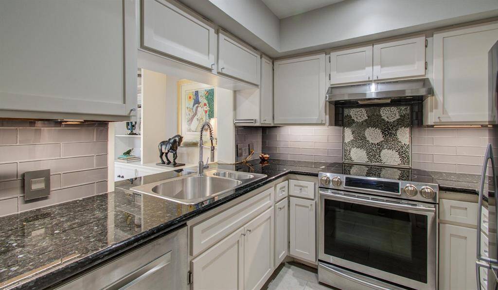 This kitchen really shines, with sparkling counters, glass backsplash and under cabinet lighting.