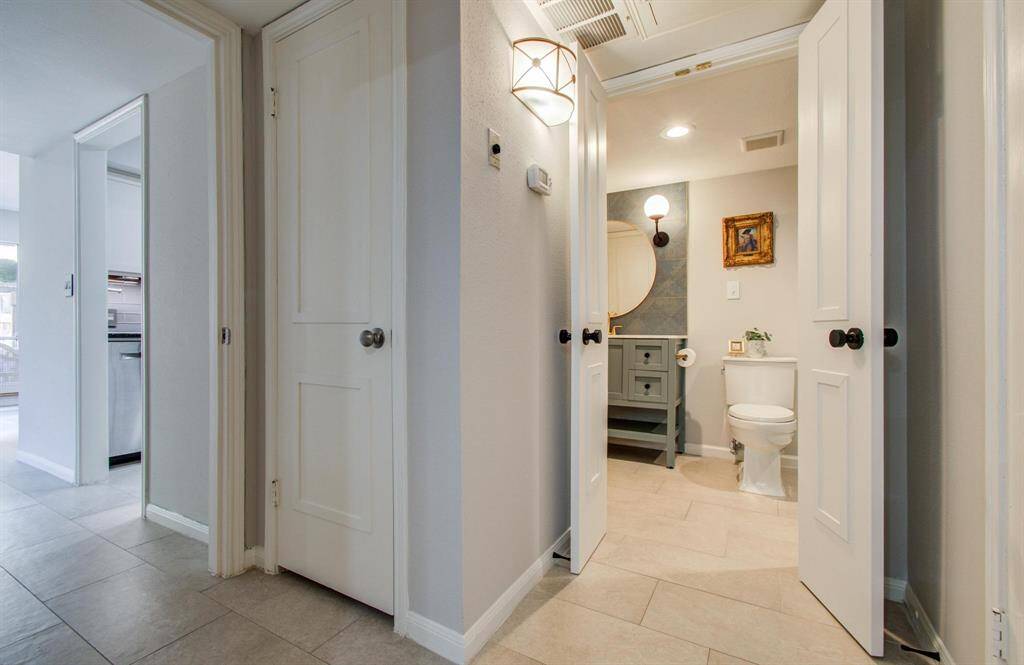 View of hallway linen closet looking into bath.  Laundry room door is slightly visible on the right.  So much storage in this place!
