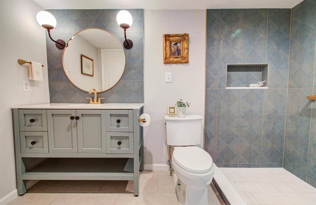 Fully redesigned bath with ample under sink storage, floor to ceiling designer tile and a recessed area in the shower for your toiletries.