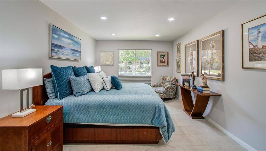 This spacious, gorgeous main bedroom has custom top down shades to allow for privacy while keeping the outdoor view!