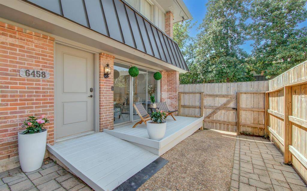 This gorgeous patio (separate dining area is to the left) awaits! Separate deck for lounging, and plenty of room for gardening, too. Custom sunshade comes with house but is not pictured. Ramp is not permanent, one step underneath.