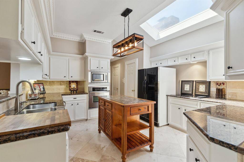MOVING INTO THE "HEART OF THE HOME".. THE KITCHEN. OPEN & BRIGHT WITH NATURAL LIGHT FROM SKY-LIGHT.. LOT'S OF CABINET SPACE, AS WELL AS 2 PANTRY CLOSETS IN HALLWAY BESIDE OVEN...