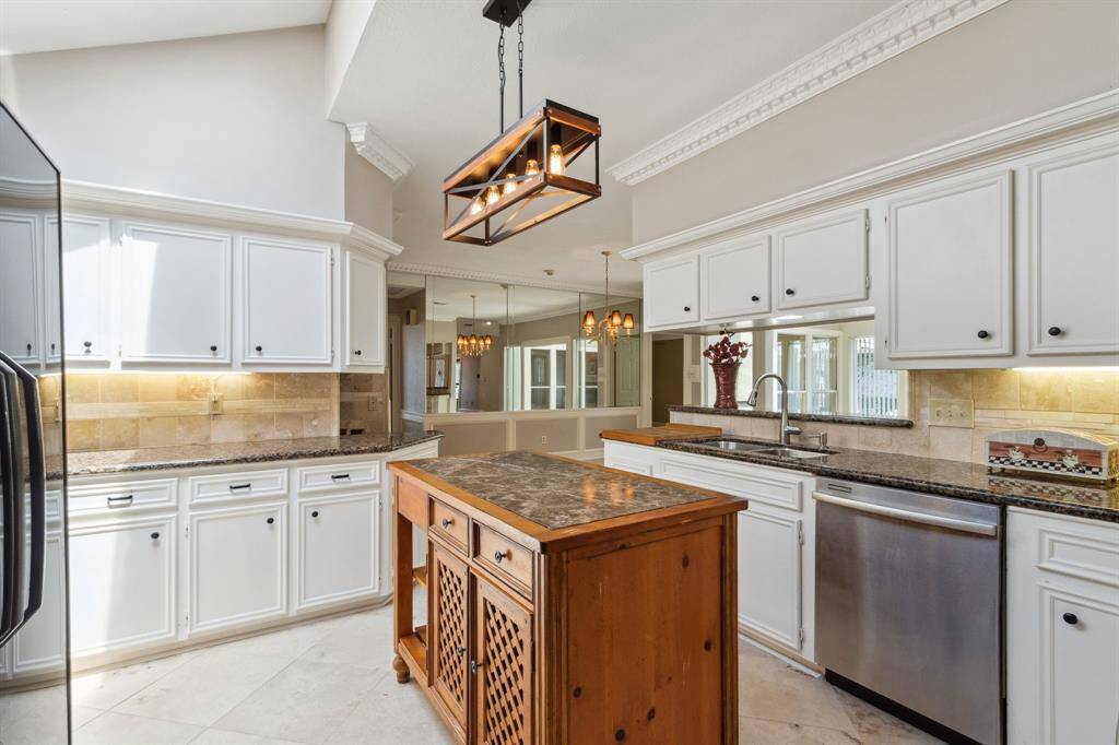 TUMBLED STONE BACKSPLASH WITH ACCENT TILE INSERTS.. UNDER COUNTER LIGHTING.. DECORATIVE LIGHTING ADDS CHARM TO THE ROOM...