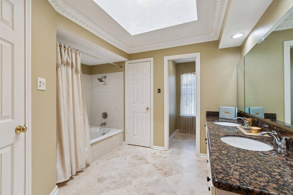 THE EN-SUITE SPA TYPE BATH LOCATED OFF THE PRIMARY BEDROOM...TRAVERTINE FLOORS CONTINUE.. DUAL WALK IN CLOSETS ON EITHER SIDE OF TUB/SHOWER..