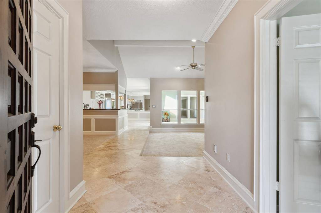 DOORWAY OPENS INTO SPACIOUS ENTRY FOYER... TRAVERTINE TILE ... CROWN TRIM .. DOOR ON LEFT IS HALL CLOSET .. DOOR ON RIGHT IS PRIVATE BEDROOM & BATH..