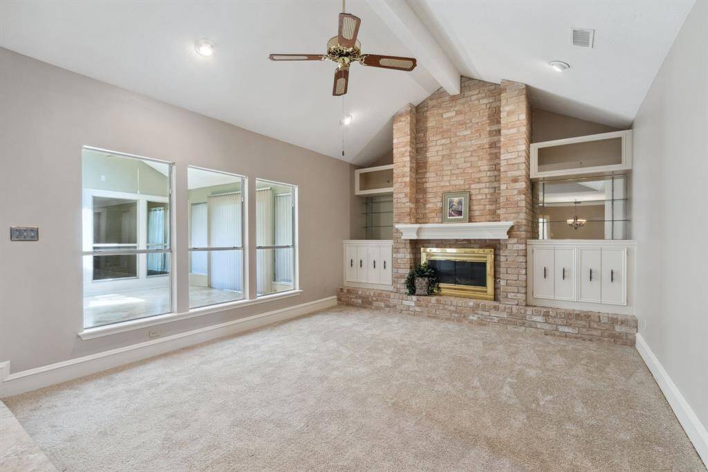 MAIN LIVING AREA WITH BEAMED CATHEDRAL CEILING... FIREPLACE WITH BRICK HEARTH.. FLANKED BY NICE BUILT-INS..CAN LIGHTING..
