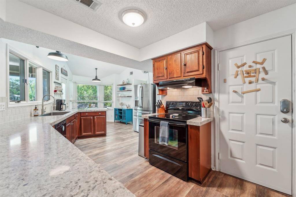 The large, spacious kitchen features granite countertops, ample cabinetry, and plenty of room for meal prep and gathering