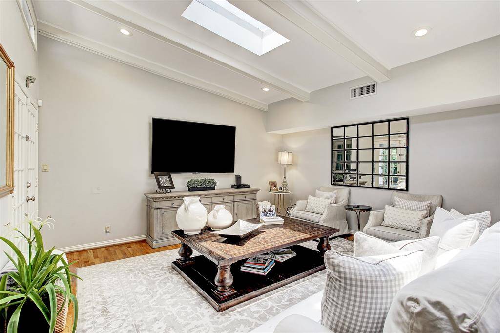 The family room is spacious and enjoys natural light from skylights above and French doors on the left that open onto the patio. The formal dining, not pictured, is adjacent to the family room and can easily accommodate 8-10 people.