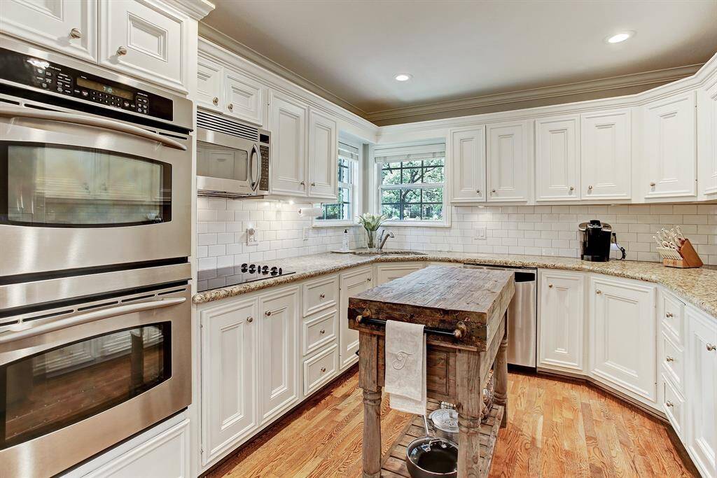 The kitchen offers great storage, stainless steel double ovens, refrigerator,  electric stove and built in microwave. The kitchen sink is in the corner under the sunny windows.