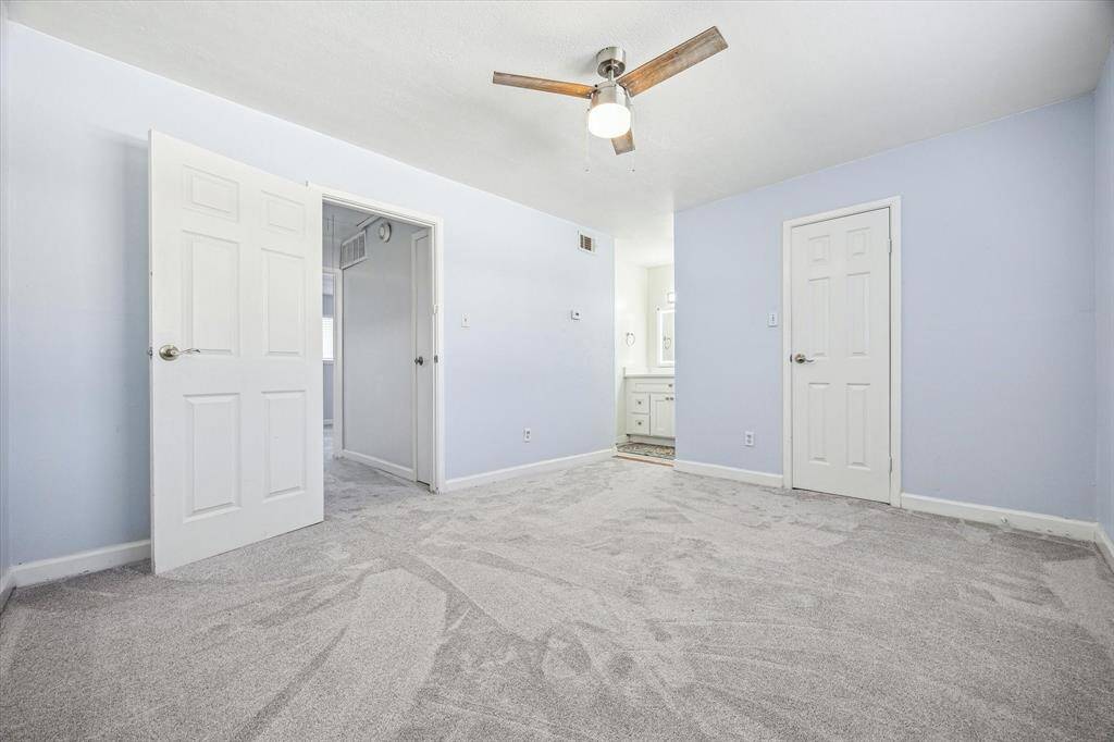 Charming second-floor bedroom with a ceiling fan and convenient access to the nearby bathroom.