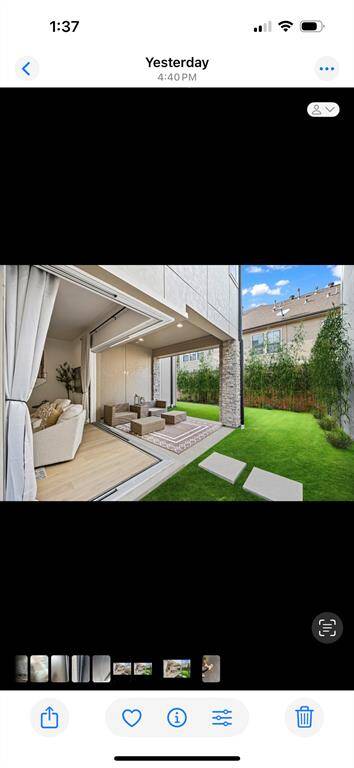 This photo showcases a modern home with a seamless indoor-outdoor living space. A cozy, open-plan interior connects to a lush green yard through large sliding doors, offering a perfect blend of relaxation and nature.