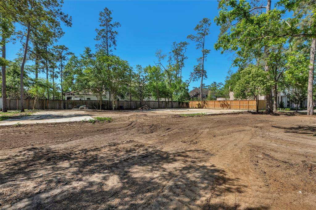 Spacious cleared wooded lot with fencing along the back and side.
