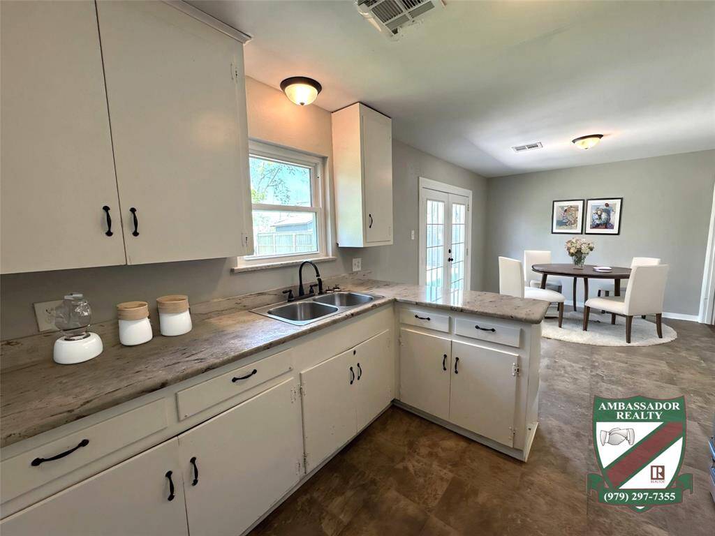 Kitchen has granite countertops and open to the dining area with French doors leading to the large back patio *Virtually staged*