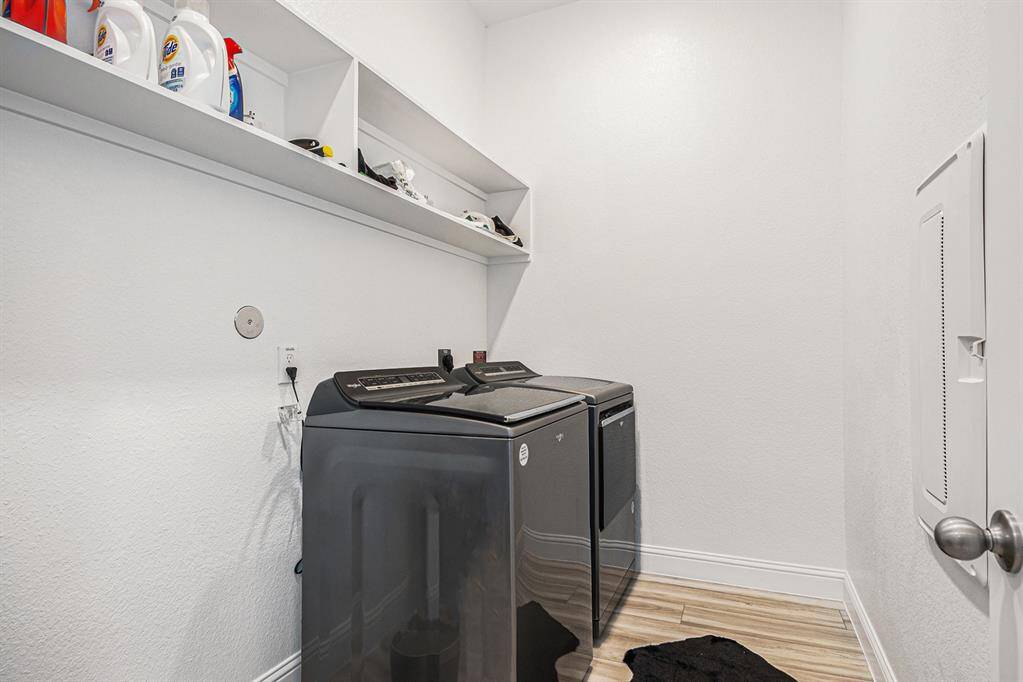 oversized laundry with side by side front loaders and ample storage space