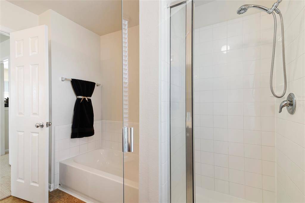Luxurious primary bath featuring a separate shower and tub for ultimate relaxation.
