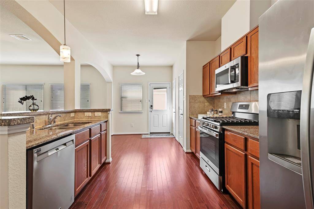 Modern kitchen with sleek granite countertops and brand-new appliances.