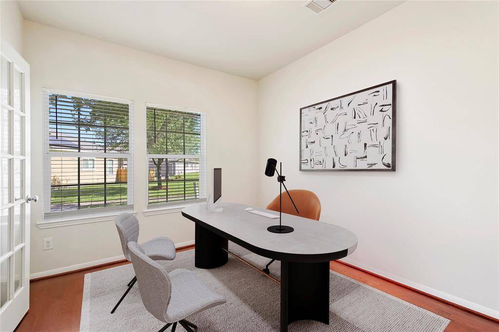 Virtual furnishing. Bright and inviting study/office with abundant natural light. Features a French door for privacy without sacrificing illumination.