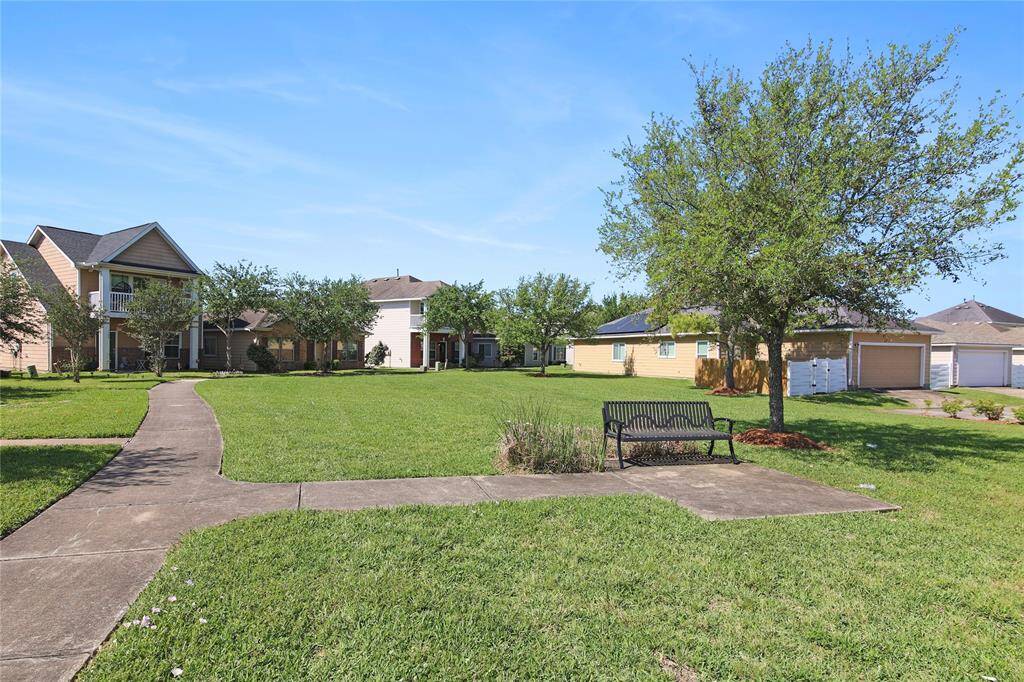 Enjoy peaceful moments in the adjacent greenspace, featuring a relaxing bench.