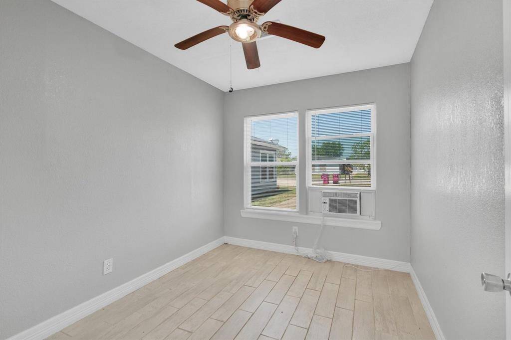 Bright and cozy bedroom with ample natural light and a stylish ceiling fan.
