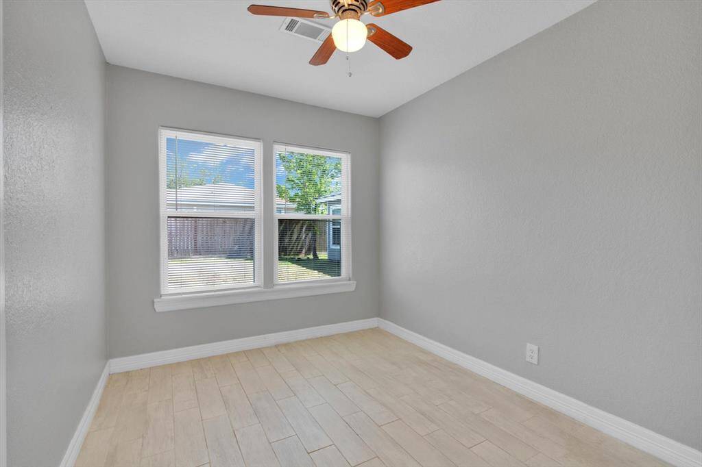 Bright and inviting bedroom with large windows and modern ceiling fan, perfect for relaxation.