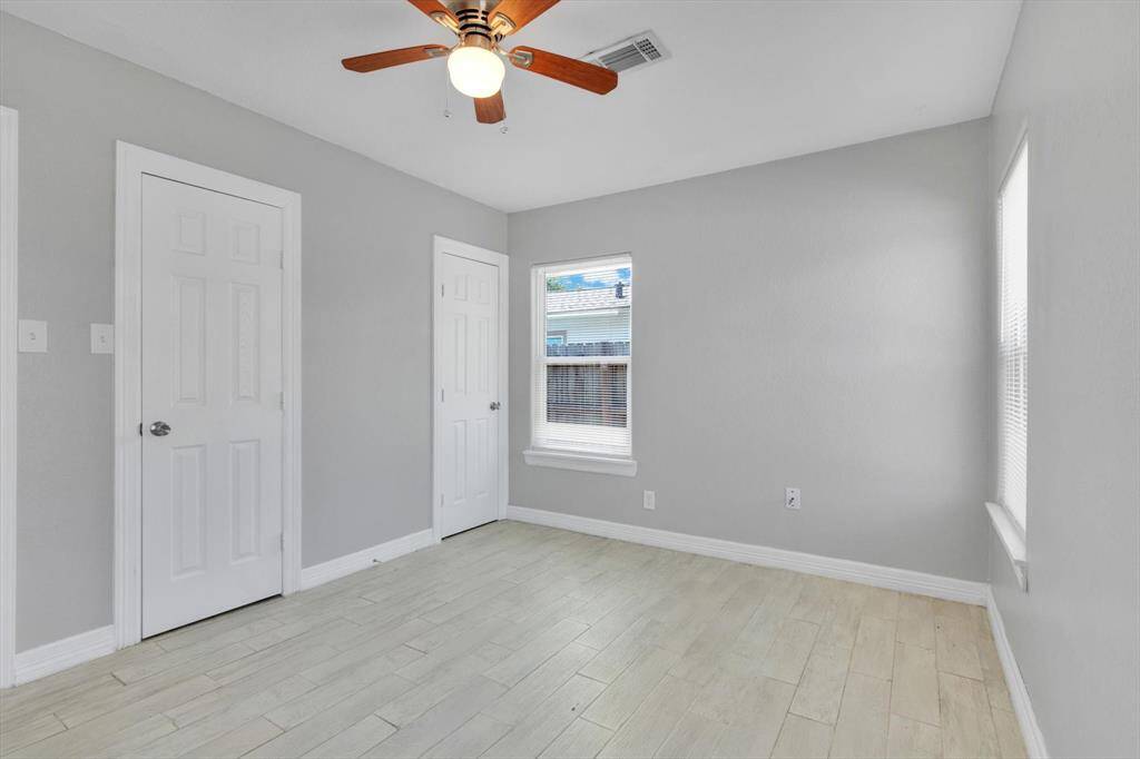 Bright and inviting, this third bedroom features sleek flooring, ample natural light, and a modern ceiling fan, perfect for relaxation or work-from-home needs.