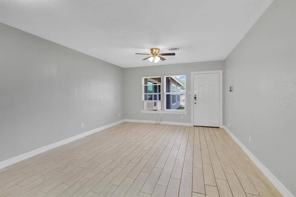 Bright and inviting living room with sleek tile flooring, neutral tones, and abundant natural light—an ideal space for relaxation and entertaining.