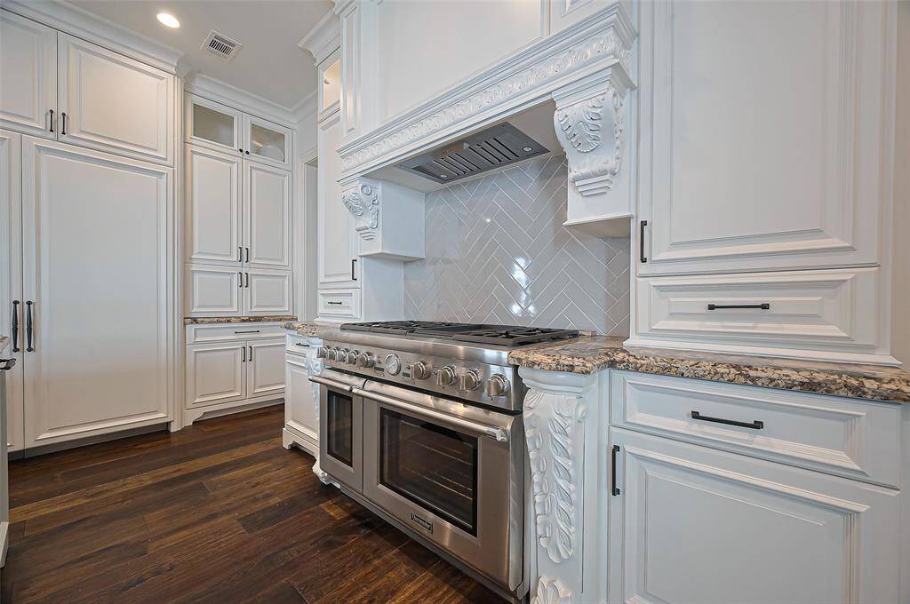 Custom soft close cabinetry with intricate details, THERMADOR APPLIANCE, BUILT IN REFRIDGERATOR, PANTRY The room has a classic, sophisticated look