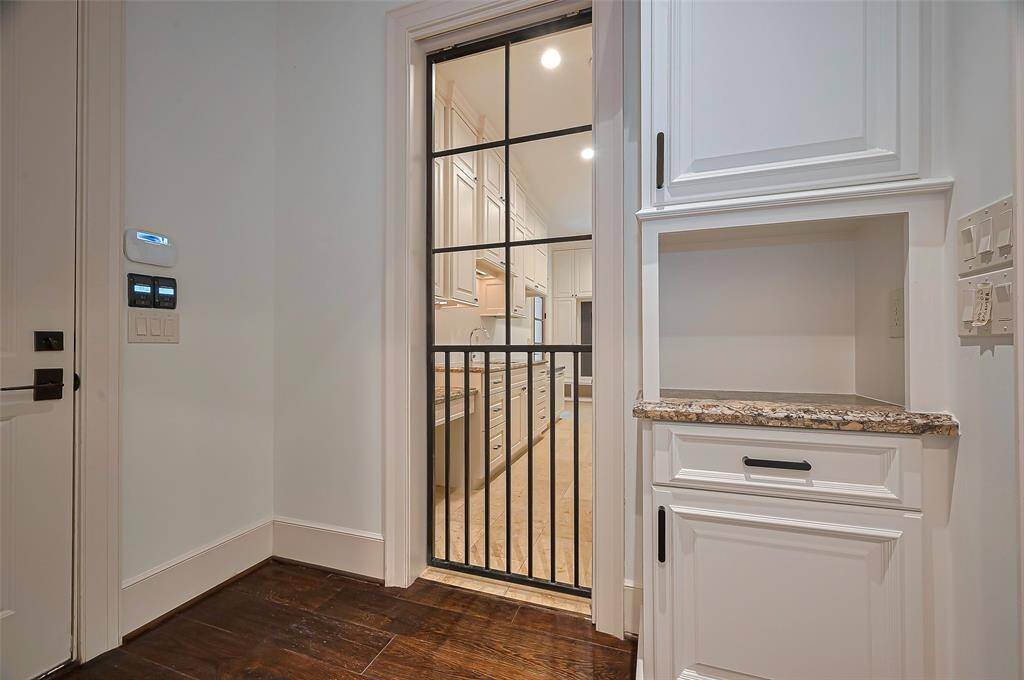 Transitional area leading to a kitchen. Features an amazing Rought iron black POCKET DOG DOOR. security keypad to the attached 3 car garage. Quickly bring in groceries.