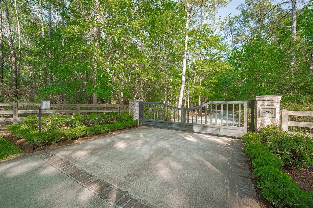 Private Home Entry Gate with keypad for guest entry or deliveries. Beautiful springtime azaleas bloom bright pink in the sunshine.