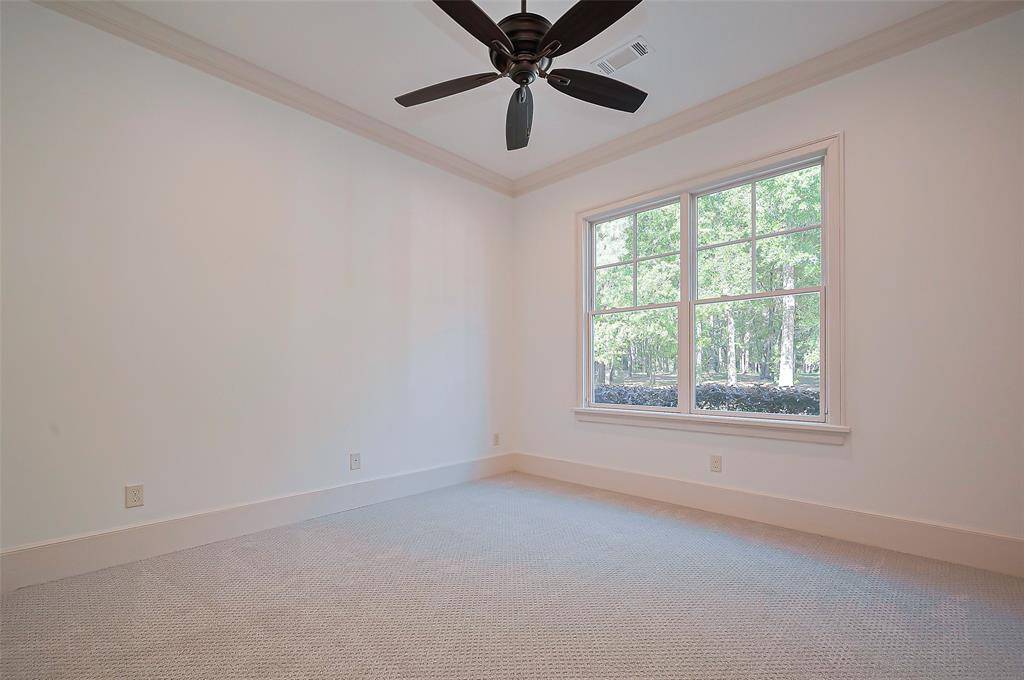 Downstairs Guest Bedroom is spacious and bright room with neutral walls and BRAND-NEW carpet. It features a large window offering a view of greenery outside, and a ceiling fan for circulation. Perfect for a mother-in-law suite or any guest will enjoy.
