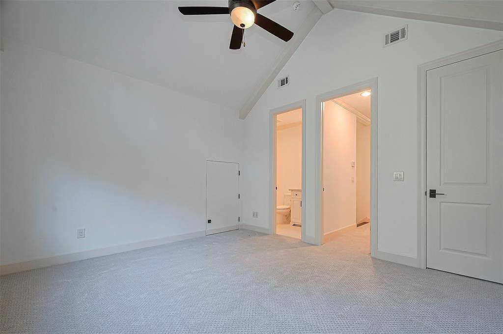 3rd Bedroom. Upstairs. Vaulted ceiling with a ceiling fan, BRAND NEW neutral carpet, and a large window that provides plenty of natural light. The circular window above adds a charming architectural detail.