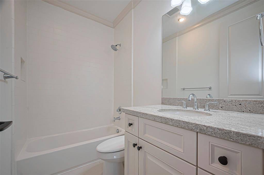 4th Bedroom bathroom clean, modern design with bathtub and shower combo, granite countertop and ample cabinet storage.