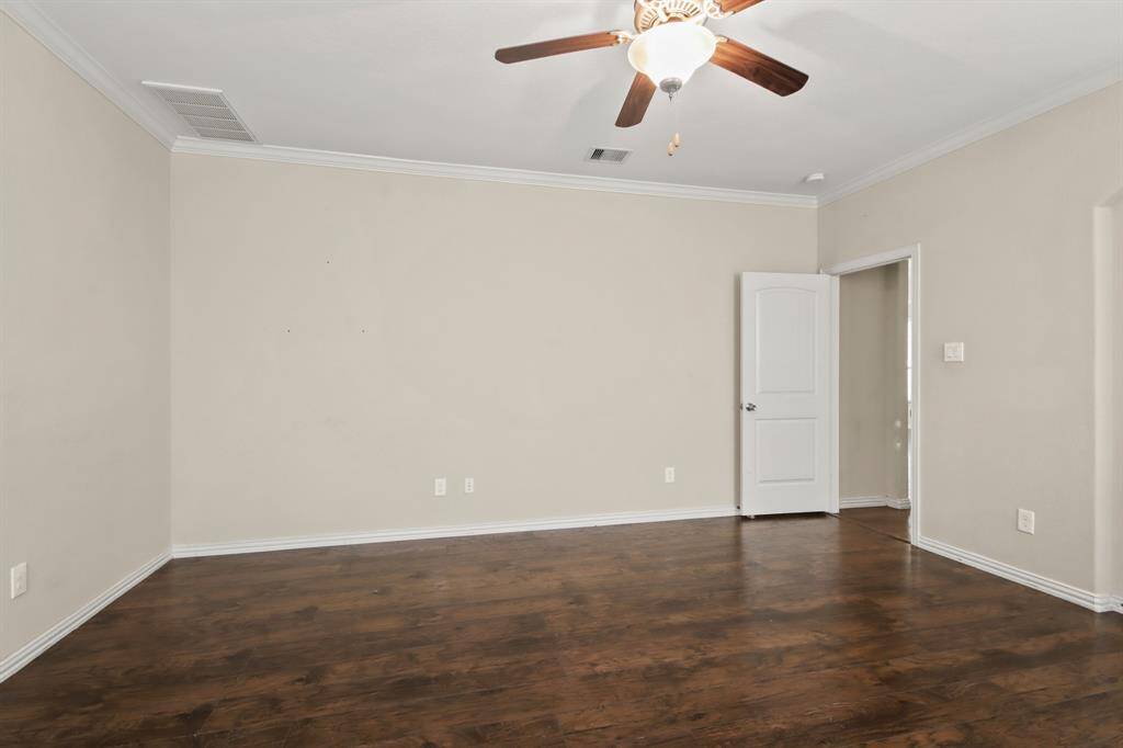 Spacious primary bedroom located on the first floor, featuring high ceilings, an ensuite bathroom, and plenty of open space.