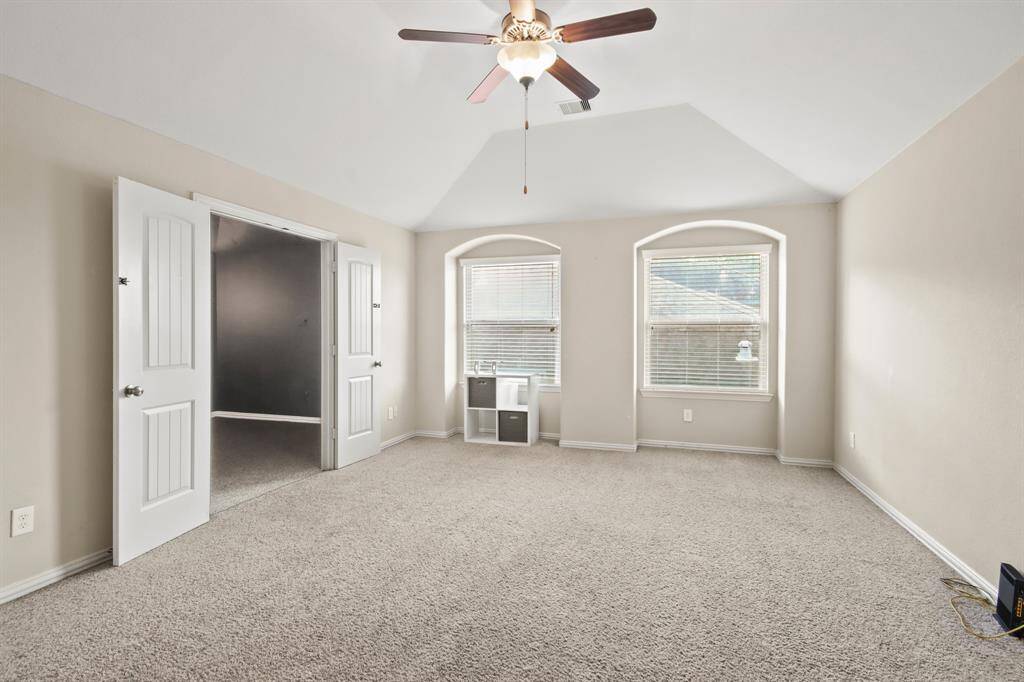Spacious primary bedroom located on the first floor, featuring high ceilings, an ensuite bathroom, and plenty of open space.