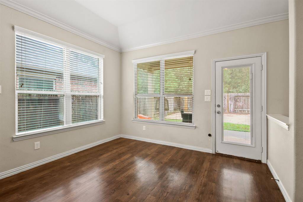 Bright breakfast area with large windows offering a view of the backyard.