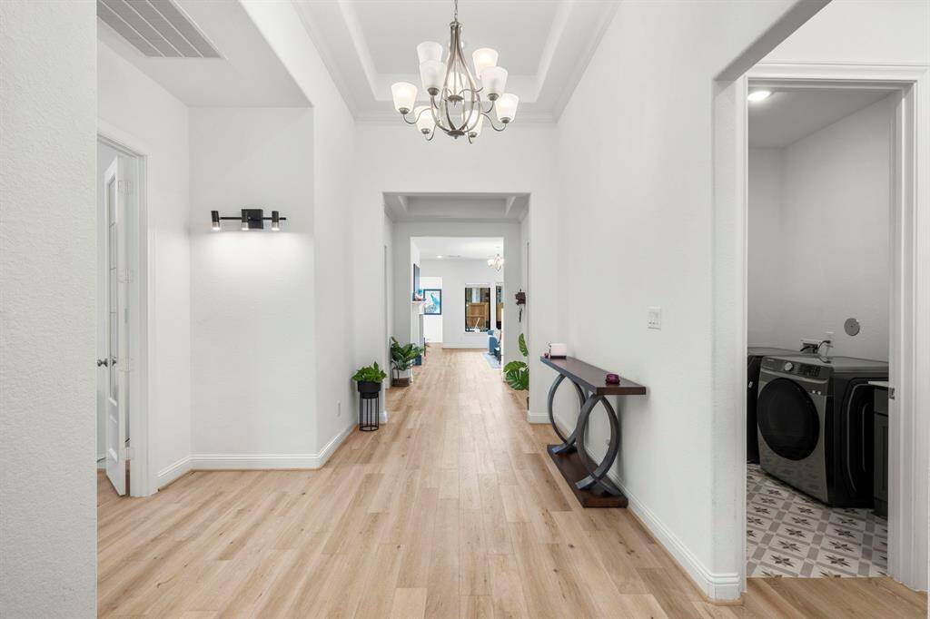 Another view of the entryway with tray ceilings in to the living area. Foyer has ample space for furniture.