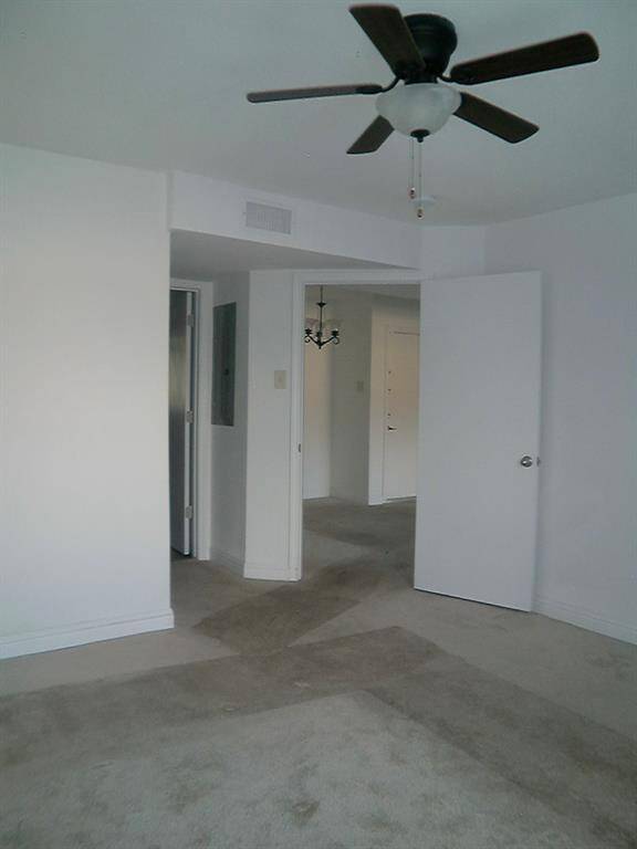 Bright and spacious third bedroom with modern ceiling fan and neutral tones.