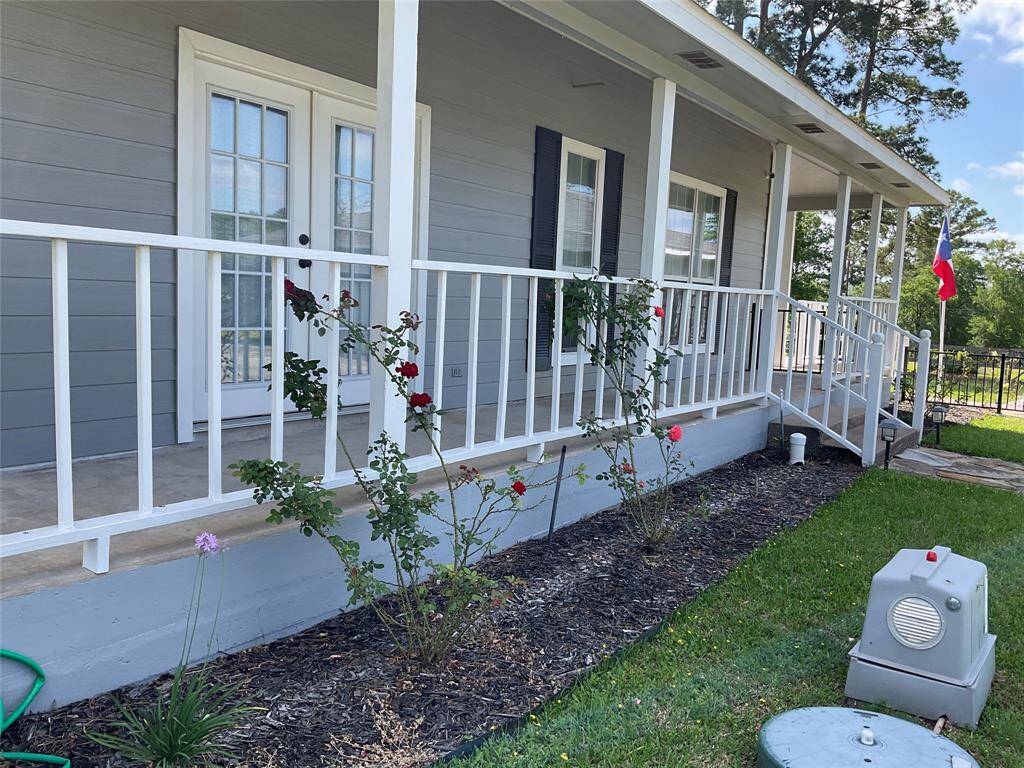 Porch between the driveway and front door. Check out the blooming rose bush.