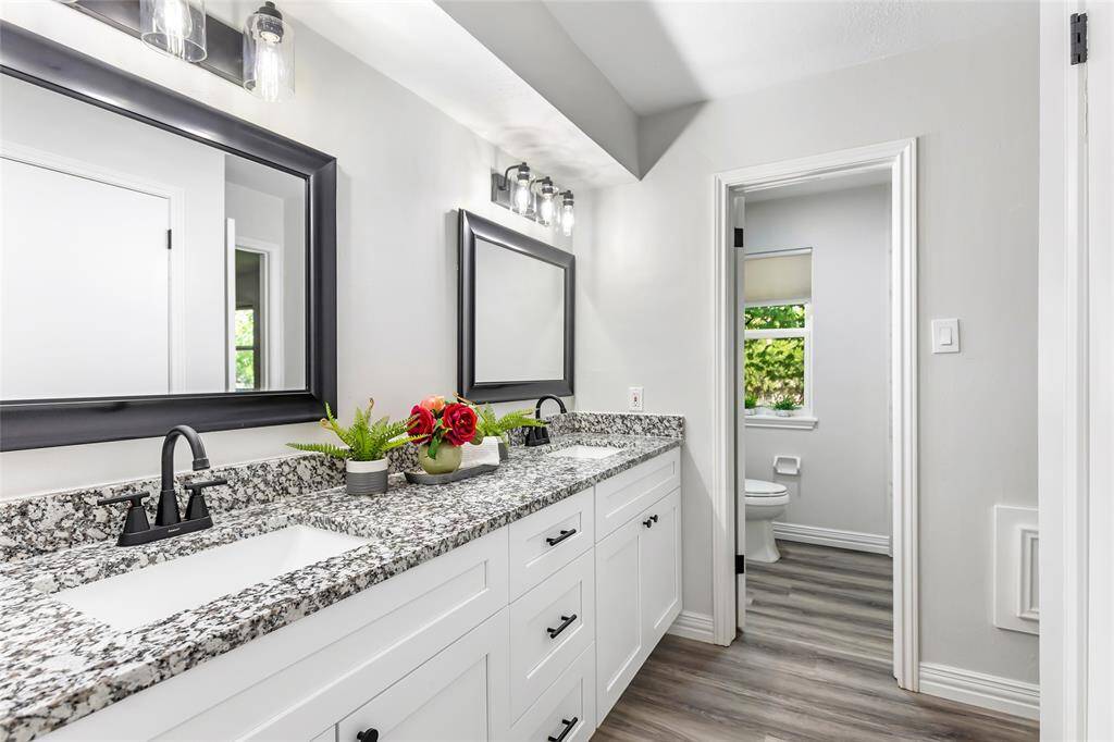 Upstairs full bathroom with dual sinks and private toilet/shower.