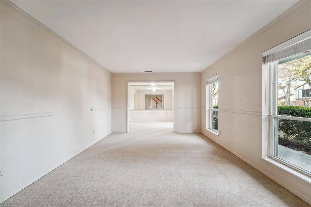 This bright, open-concept living area features a combo living/dining room with large windows and a seamless flow into the kitchen.