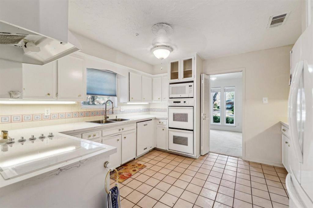 Recently upgraded kitchen featuring freshly painted white cabinetry and quartz countertops.