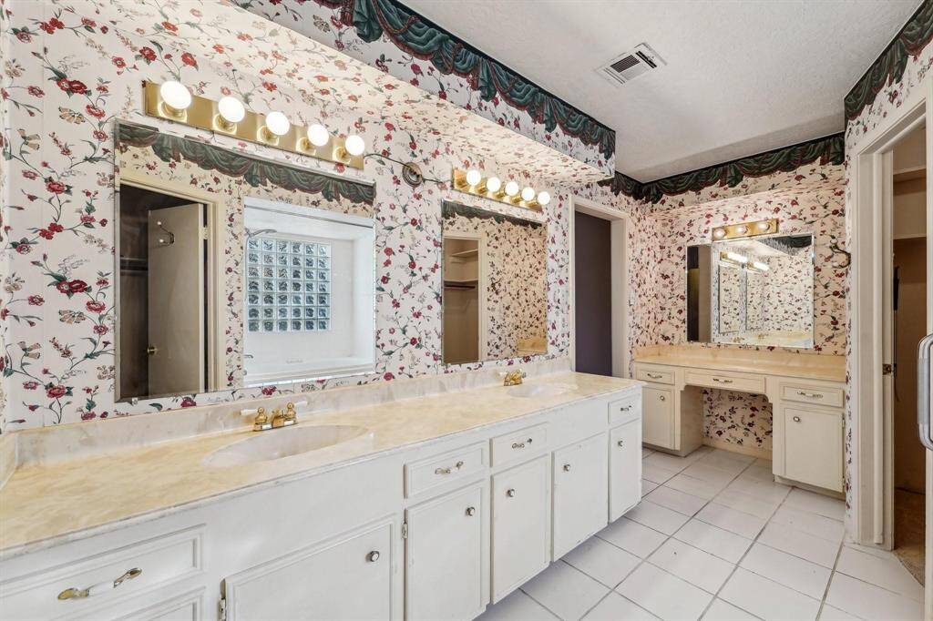 Primary bathroom features dual sinks with ample counter space, and a separate vanity area.
