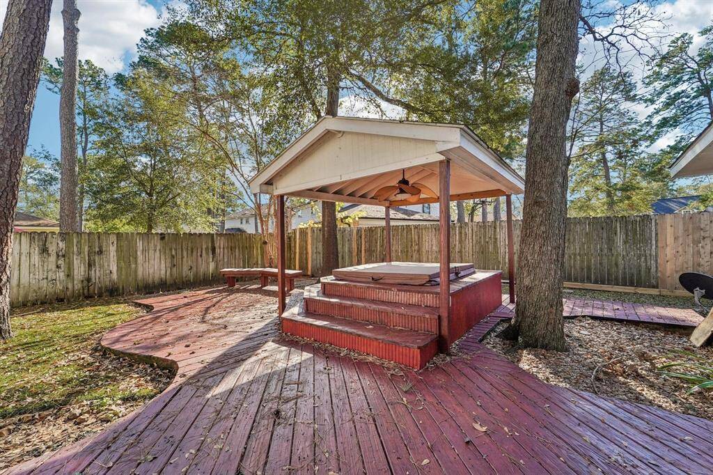 Backyard features artificial grass and a recently repaired deck leading to a hot tub!