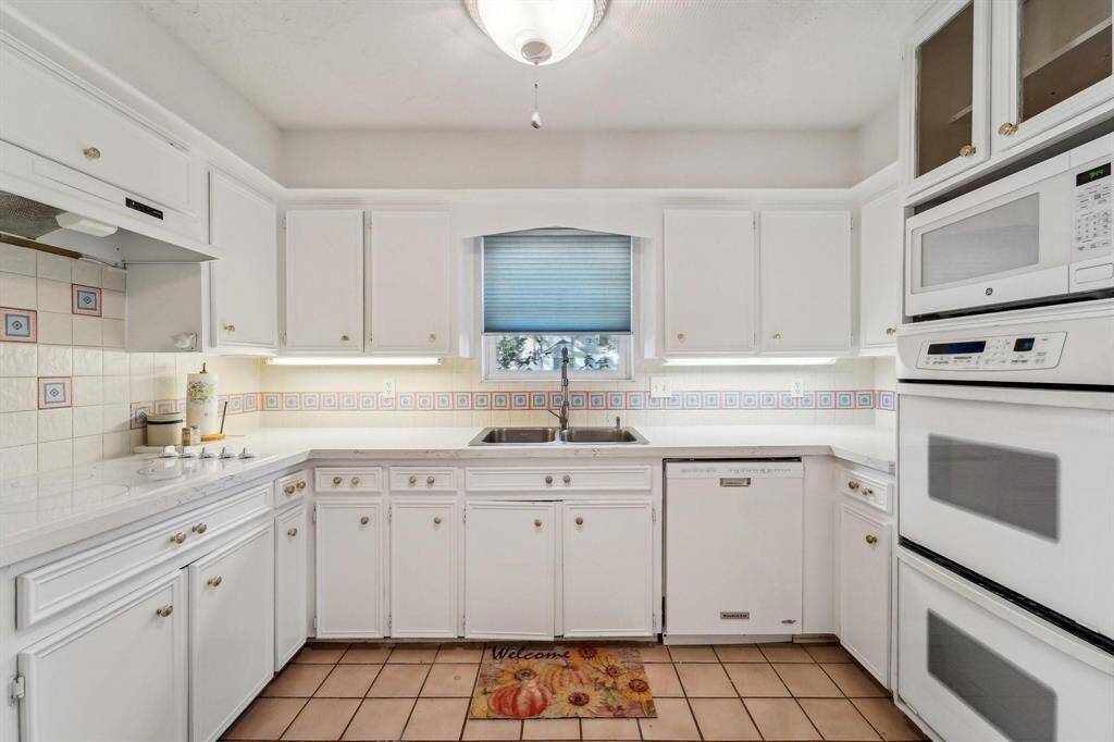 Recently upgraded kitchen featuring freshly painted white cabinetry and quartz countertops.