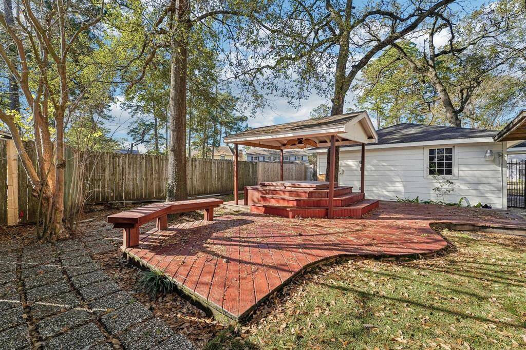 Backyard features artificial grass and a recently repaired deck leading to a hot tub!
