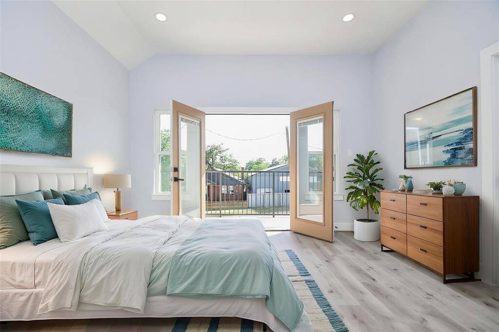 The primary bedroom features wide open doors leading to the balcony, with virtual staging offering a glimpse of the elegance and comfort that await.