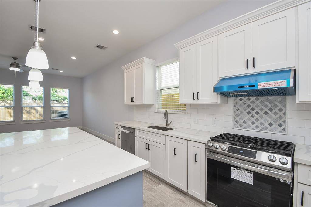 New appliances enhance this gourmet kitchen, featuring quartz countertops, ample counter space, and plenty of cabinet and storage options.