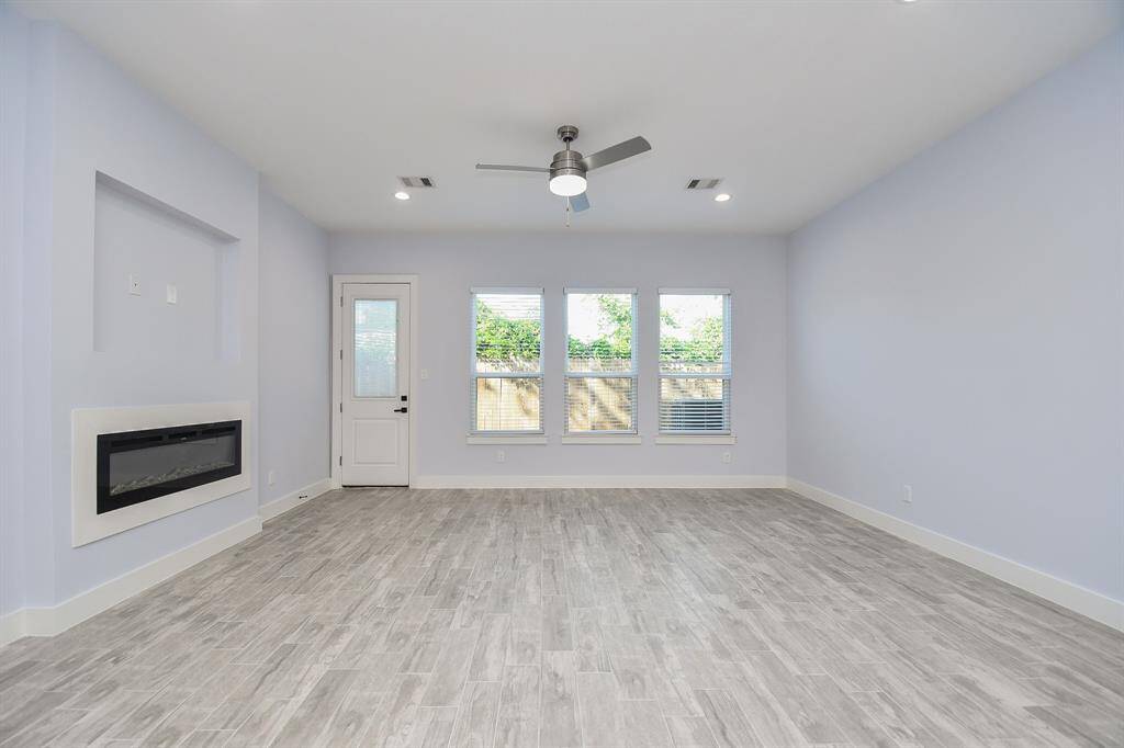 With expansive windows that let in plenty of natural light and a cozy fireplace, the family room offers a warm and inviting atmosphere.