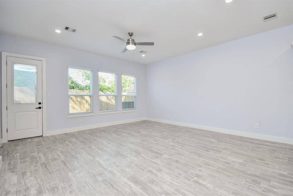 The family room is enhanced by beautiful flooring, large windows that fill the space with natural light, and soaring tall ceilings.